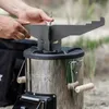 A person is assembling a rocket stove outdoors. Produktbild-Vorschau