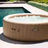 An inflatable hot tub is situated on a patio next to a swimming pool. Náhľad obrázku produktu