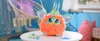 A fluffy toy sits on a white table in a brightly decorated room. Anteprima dell’immagine prodotto
