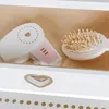 A close-up view of a toy hairdryer and hairbrush inside a drawer. Podgląd zdjęcia produktu