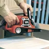 A person is using a belt sander on a piece of furniture. Anteprima dell’immagine prodotto