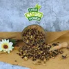 A bowl of dried carob pieces with a wooden scoop and a flower on a burlap cloth, with a logo in the background. Produktbild-Vorschau