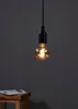 A single light bulb hanging from a black cord against a dark gray background. Náhľad obrázku produktu