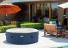 An inflatable hot tub is set up on a patio next to outdoor furniture and an umbrella. Produktbild-Vorschau