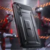 A rugged phone case is displayed in a futuristic, industrial setting with robotic arms. Produktbild-Vorschau