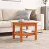 A wooden side table with books and a mug on it, placed next to a sofa. Náhled obrázku produktu