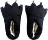 A pair of black slippers shaped like monster or dragon feet with claws, shown from a front-facing perspective against a white background. Náhled obrázku produktu