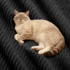 A cat is lying on a dark gray textured surface. Produktbild-Vorschau