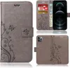 A collage of images showing a grey flip phone case with a floral and butterfly design, with different views and angles. Produktbild-Vorschau