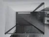 A top-down view of a modern shower enclosure with a dark tiled floor and light gray walls. Podgląd zdjęcia produktu