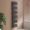 A modern anthracite radiator in a bathroom setting, next to a plant and a shower enclosure. Produktbild-Vorschau