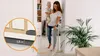 A woman is holding a baby and walking through a doorway with a baby gate installed. Náhled obrázku produktu
