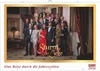 A large group of people posing for a photo in a formal indoor setting, likely a staircase in a mansion. Produktbild-Vorschau
