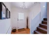 A hallway with a white door, stairs, and decorative items. Produktbild-Vorschau