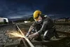 A person is using an angle grinder on a railway track at night. Náhľad obrázku produktu