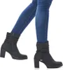 A person wearing blue jeans and black ankle boots. Voir les images du produit