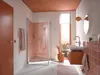 A modern bathroom with pink tiled walls and a walk-in shower. Produktbild-Vorschau