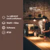 A barista is preparing coffee behind a counter with a pendant lamp hanging above. Produktbild-Vorschau