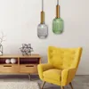 A living room scene with a yellow armchair, a wooden cabinet, and two pendant lights. Produktbild-Vorschau