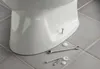 A close-up view of the base of a white toilet, showing mounting hardware and tools on a tiled floor. Produktbild-Vorschau