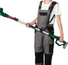 A person wearing gray overalls and a white t-shirt holds a green and silver telescopic hedge trimmer. Produktbild-Vorschau
