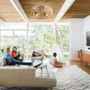 A family relaxing in a modern living room with large windows. Produktbild-Vorschau