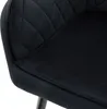 A close-up view of a black velvet dining chair, showing the quilted backrest and seat. Produktbild-Vorschau