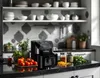 A black air fryer on a kitchen counter with ingredients. Podgląd zdjęcia produktu