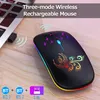 A black wireless mouse with colorful LED lights and a phoenix design is placed on a wooden surface next to a laptop. Produktbild-Vorschau