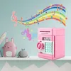 A pink electronic piggy bank with a keypad and dial is displayed on a shelf next to a pink bunny toy and a gray whale toy. Musical notes and a rainbow wave are decorated on the wall behind the products. Náhľad obrázku produktu