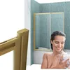 A woman is taking a shower in a bathtub with a shower enclosure. Produktbild-Vorschau