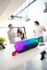 People are having a party and singing into a microphone while a colorful speaker is on a table. Voir les images du produit
