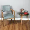 A chair and a small side table with a teapot and vase of dried flowers. Produktbild-Vorschau