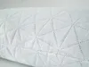 A close-up view of a white pillow with a geometric stitched pattern. Produktbild-Vorschau