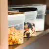 Three plastic food storage containers with lids are lined up on a shelf. Produktbild-Vorschau