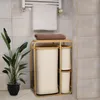 A bathroom scene with a laundry basket, towels, and a plant. Podgląd zdjęcia produktu