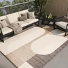 An outdoor patio setting with a sofa, armchair, coffee table, and a rug. Voir les images du produit