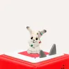 A small white bunny figurine with Christmas lights is sitting on a red and white surface, with two gray shark fins protruding from the surface. Produktbild-Vorschau
