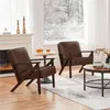 Two brown armchairs are placed in a living room with a fireplace and a window overlooking a snowy landscape. Produktbild-Vorschau