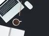 A flat lay of a laptop, mouse, coffee cup, and notebook on a black surface. Produktbild-Vorschau