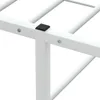Close-up view of a white metal bed frame, focusing on a corner joint with a black plastic cap. Náhľad obrázku produktu