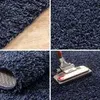 A collage of four images showing a close-up of a navy blue shaggy rug, including its texture, edge, and a vacuum cleaner on it. Produktbild-Vorschau