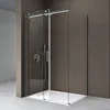 A modern shower cabin with a sliding door, featuring a shower head and controls, set against a textured brown wall and a light gray floor.