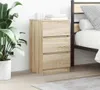 A bedside table with three drawers is placed next to a bed, with a large potted plant on the left. Anteprima dell’immagine prodotto