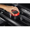 A hand is shown adjusting a red and black locking mechanism on a black roof box. Produktbild-Vorschau
