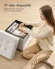 A woman is placing items into a storage ottoman. Produktbild-Vorschau