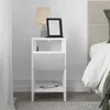 A white nightstand with a lamp and an e-reader on top, and a phone charging on the bottom shelf. Produktbild-Vorschau