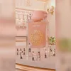 Miniature figures are cleaning and painting a giant perfume bottle. Voir les images du produit
