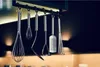 A collection of kitchen utensils hanging from a rack. Anteprima dell’immagine prodotto