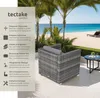 A rattan armchair on a patio overlooking a beach. Produktbild-Vorschau
